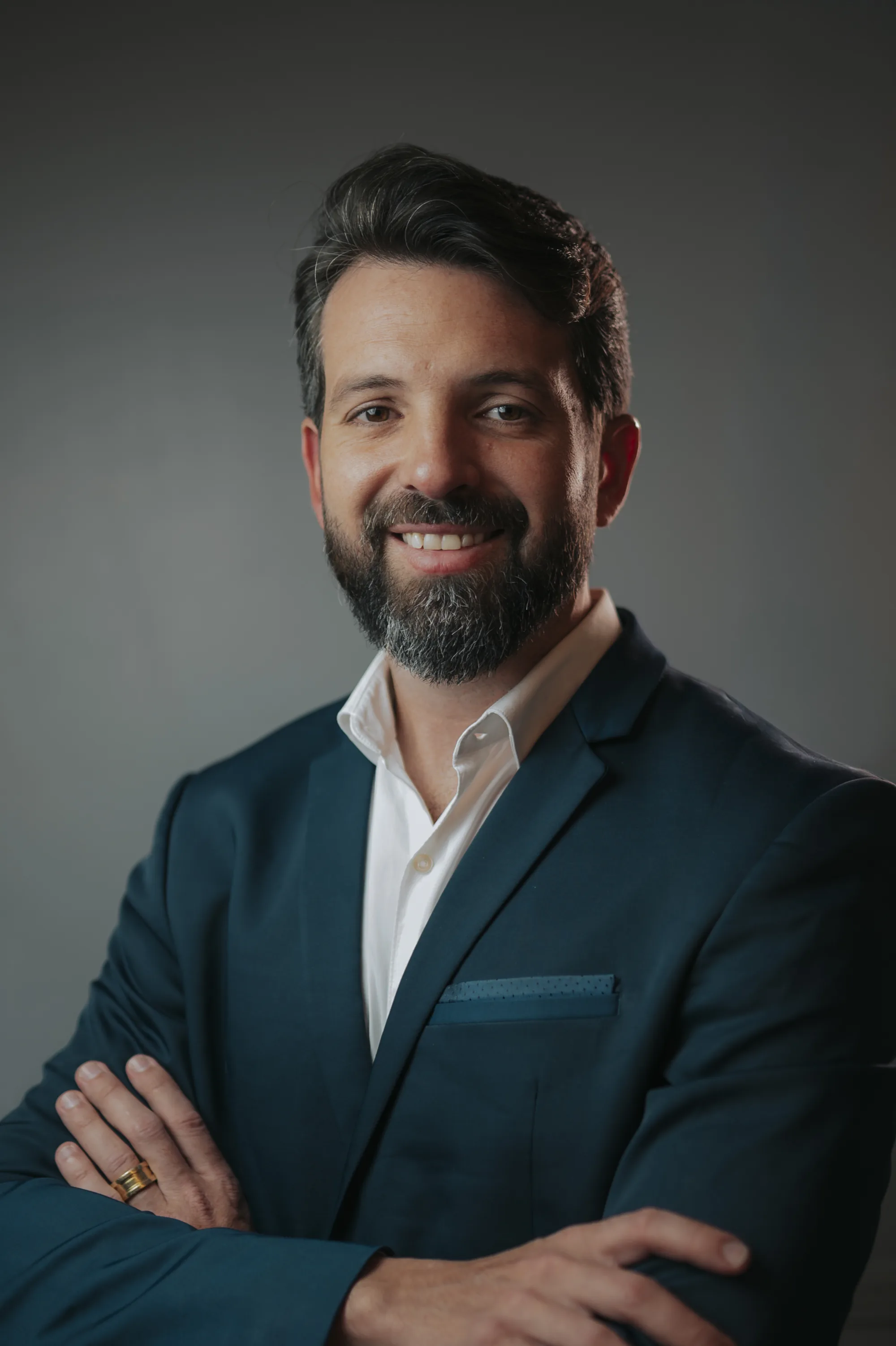 Dr. Guilherme Lobo, médico, sorrindo em ambiente sofisticado com madeira e plantas